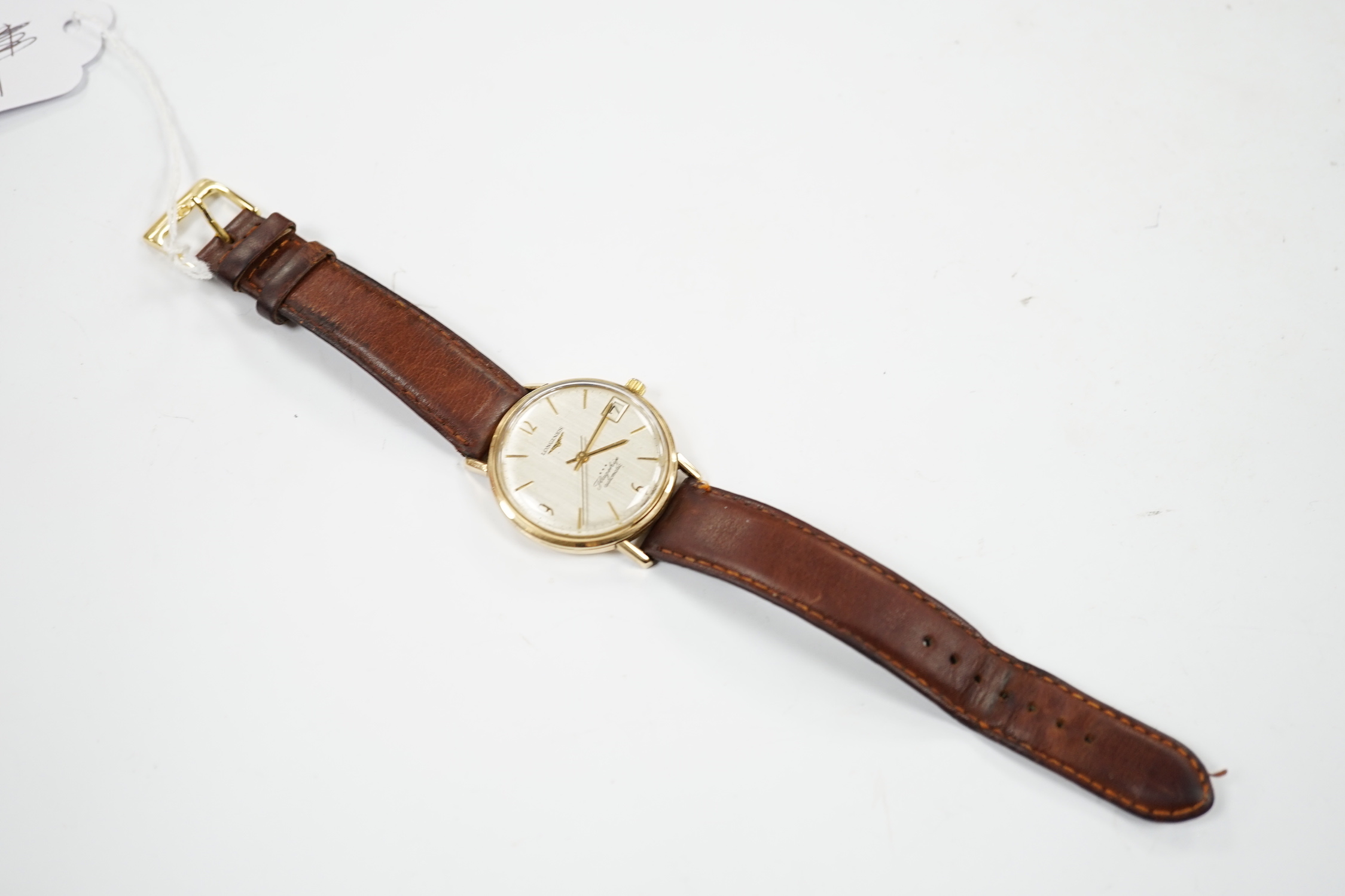 A gentleman's 9ct gold Longines Flagship automatic wrist watch, with baton numerals and date aperture, on associated leather strap.